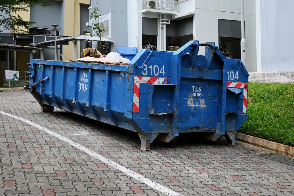 Grote blauwe afvalcontainer voor bouwafval op straat